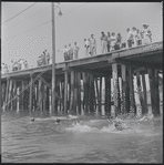 Pier with swimmers in foreground