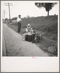 A hitchhiking family waiting along the highway in Macon, Georgia. The father repairs sewing machines, lawn mowers, etc. He is leaving Macon, where a license is required for such work (twenty-five dollars) and heading back for Alabama