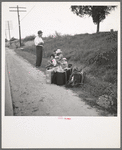 A hitchhiking family waiting along the highway in Macon, Georgia. The father repairs sewing machines, lawn mowers, etc. He is leaving Macon, where a license is required for such work (twenty-five dollars) and heading back for Alabama