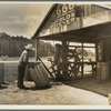 Turpentine still near Valdosta, Georgia. The "cooper" makes barrels to hold the gum