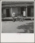 Negro wage laborer and part of his family. He is coming home from the commissary with a week's rations. Macon County, Georgia