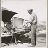 Car trouble on west side of Highway No. 33 in San Joaquin Valley. Formerly a California cowhand and roving laborer. Now with his wife, he follows the fruit. "My uncle homesteaded here sixty years ago. I'm lower on money than at any time"