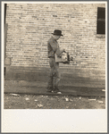 Cotton picker during strike carrying his Farm Security Administration grant of food and necessities from warehouse to Farm Security Administration Shafter camp for migrants, where he lives with his family. Bakersfield, California