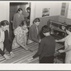 In the sewing room, migrant women are instructed in rug-making. Shafter camp for migrants (Farm Security Administration-FSA), California