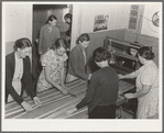 In the sewing room, migrant women are instructed in rug-making. Shafter camp for migrants (Farm Security Administration-FSA), California