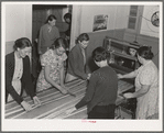 In the sewing room, migrant women are instructed in rug-making. Shafter camp for migrants (Farm Security Administration-FSA), California