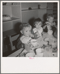 Lunchtime for young migrants at Shafter Camp, California. The nursery school for migrant children is conducted in camp under nursery school teachers trained by WPA (Work Projects Administration), and assigned to work in the camp under (WPA) project