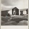 United States government camp for migrants (Farm Security Administration), Farmersville, California. Prefabricated steel dwellings "one step up from a tent" replace the use of tents in the newer California camps