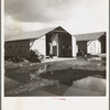 United States government camp for migrants (Farm Security Administration), Farmersville, California. Prefabricated steel dwellings "one step up from a tent" replace the use of tents in the newer California camps