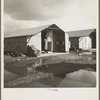 United States government camp for migrants (Farm Security Administration), Farmersville, California. Prefabricated steel dwellings "one step up from a tent" replace the use of tents in the newer California camps