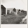 United States government camp for migrants (Farm Security Administration), Farmersville, California. Prefabricated steel dwellings "one step up from a tent" replace the use of tents in the newer California camps