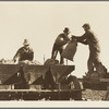 Loading bins of potato planter which fertilizes and plants potatoes in one operation. Kern County, California