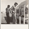 Farm Security Administration (FSA) migratory labor camp (emergency). Migratory workers, in camp for the pea harvest, scan the bulletin board at entrance
