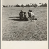 Marble time in Farm Security Administration (FSA) migratory labor camp (emergency). Plenty of space to play and plenty of companions for the children during pea harvest. Near Calipatria, Imperial Valley. California