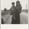 On U.S. 99. Near Brawley, Imperial County. Homeless mother and youngest child of seven walking the highway from Phoenix, Arizona where they picked cotton. Bound for San Diego, where the father hopes to get on relief "because he once lived there."