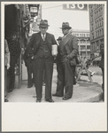 Salvation Army, San Francisco, California. Men pause a moment to watch, and then pass on