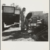 In a carrot puller' camp near Holtville, Imperial Valley, California. Migratory laborers from Texas, packing up to leave camp because of work shortage. "Don't take any pictures of us. We don't want any truck with Mr. Hearst"