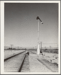 Looking east down the railroad track, near Calipatria, California. Single men, itinerants with "bindles" waiting for the freight