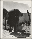 A grandmother washing clothes in a migrant camp. Stanislaus County, California