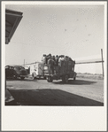 Labor contractor's truck with gang of pea pickers, pulled up for gas. Near Westley, California