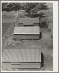 Farm Security Administration (FSA) camp for migratory agricultural workers. Farmersville, California. Shows prefabricated steel shelters which have been erected to replace tents as standard camp equipment in two of the California camps