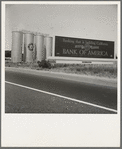 Between Tulare and Fresno on U.S. 99. Highway gas tanks and signboard approaching town. See general caption