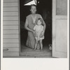 Tulare County, Farm Security Administration (FSA) camp. Migrant mother and child at doorway of steel shelter