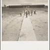 Farm Security Administration (FSA) camp at Farmersville. Nursery school children showing community laundry building. California