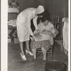 Tulare County, California. Farm Security Administration (FSA) camp for migratory agricultural workers at Farmersville. Nurse of Agricultural Workers' Health and Medical Association (FSA) is assigned to camp. Photo shows her attending sick baby