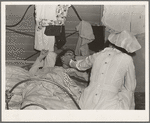 Tulare County, California. Farm Security Administration (FSA) camp for migratory agricultural workers at Farmersville. Nurse of Agricultural Workers' Health and Medical Association attends sick migrant woman while awaiting doctor