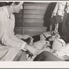 Tulare County, California. Farm Security Administration (FSA) camp for migratory agricultural workers at Farmersville. Nurse of Agricultural Workers' Health and Medical Association attends sick migrant woman while awaiting doctor