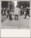 42nd Street and Madison Avenue. Street hawker selling Consumer's Bureau Guide. New York City