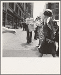 42nd Street and Madison Avenue. Street hawker selling Consumer's Bureau Guide. New York City