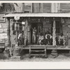 Country store on dirt road. Sunday afternoon. Note the kerosene pump on the right and the gasoline pump on the left. Rough, unfinished timber posts have been used as supports for porch roof. Negro men are sitting on the porch. Brother of store owner stands in doorway. Gordonton, North Carolina