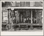 Country store on dirt road. Sunday afternoon. Note the kerosene pump on the right and the gasoline pump on the left. Rough, unfinished timber posts have been used as supports for porch roof. Negro men are sitting on the porch. Brother of store owner stands in doorway. Gordonton, North Carolina