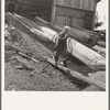 "Pond monkey" carrying cable from mill shed to pond. Keno, Klamath County, Oregon