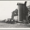 Yard of one of the eight cooperating farmers whose corn is being stored on this day. Note the newly built silo and the ensilage cutter in use. Near West Carlton, Yamhill Country, Oregon. General caption number 58.