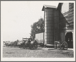 Yard of one of the eight cooperating farmers whose corn is being stored on this day. Note the newly built silo and the ensilage cutter in use. Near West Carlton, Yamhill Country, Oregon. General caption number 58.