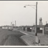 Looking down one street in newly completed camp (FSA - Farm Security Administration). Note garbage disposal, street lights, street curbing, water tank, and manager's house at end of street. Near McMinnville, Yamhill County, Oregon.