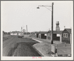 Looking down one street in newly completed camp (FSA - Farm Security Administration). Note garbage disposal, street lights, street curbing, water tank, and manager's house at end of street. Near McMinnville, Yamhill County, Oregon