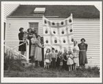 Farm women of the "Helping Hand" club display a pieced quilt which they are making for the benefit of one of their numbers. Near West Carlton, Yamhill County, Oregon. General caption number 58-11