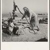 Mrs. Soper with youngest child at the well. Willow creek area, Malheur County, Oregon