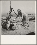 Mrs. Soper with youngest child at the well. Willow creek area, Malheur County, Oregon