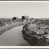 Irrigation canal and the preacher's farm. These large haystacks are characteristic of the country at this period of development. Dead Ox Flat, Malheur County, Oregon