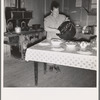 Mrs. Wardlow getting dinner after church in her basement dugout home. Dead Ox Flat, Malheur County, Oregon