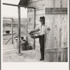 New settler shows fish he caught this morning. He "likes it fine here." Priest River Valley, Bonner County, Idaho. See general caption 54