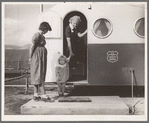 Young mother brings her child to the trailer clinic on the day when the doctor will be in camp to examine some of the children. FSA (Farm Security Administration) mobile camp. Merrill, Klamath County, Oregon