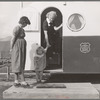 Young mother brings her child to the trailer clinic on the day when the doctor will be in camp to examine some of the children. FSA (Farm Security Administration) mobile camp. Merrill, Klamath County, Oregon