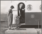 Young mother brings her child to the trailer clinic on the day when the doctor will be in camp to examine some of the children. FSA (Farm Security Administration) mobile camp. Merrill, Klamath County, Oregon