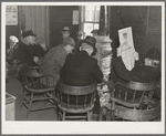 Weighing-in room of the stockyards. Aledo, Illinois. Farmers sitting around the stove enjoying themselves and getting warm. The stove is still a middle western institution